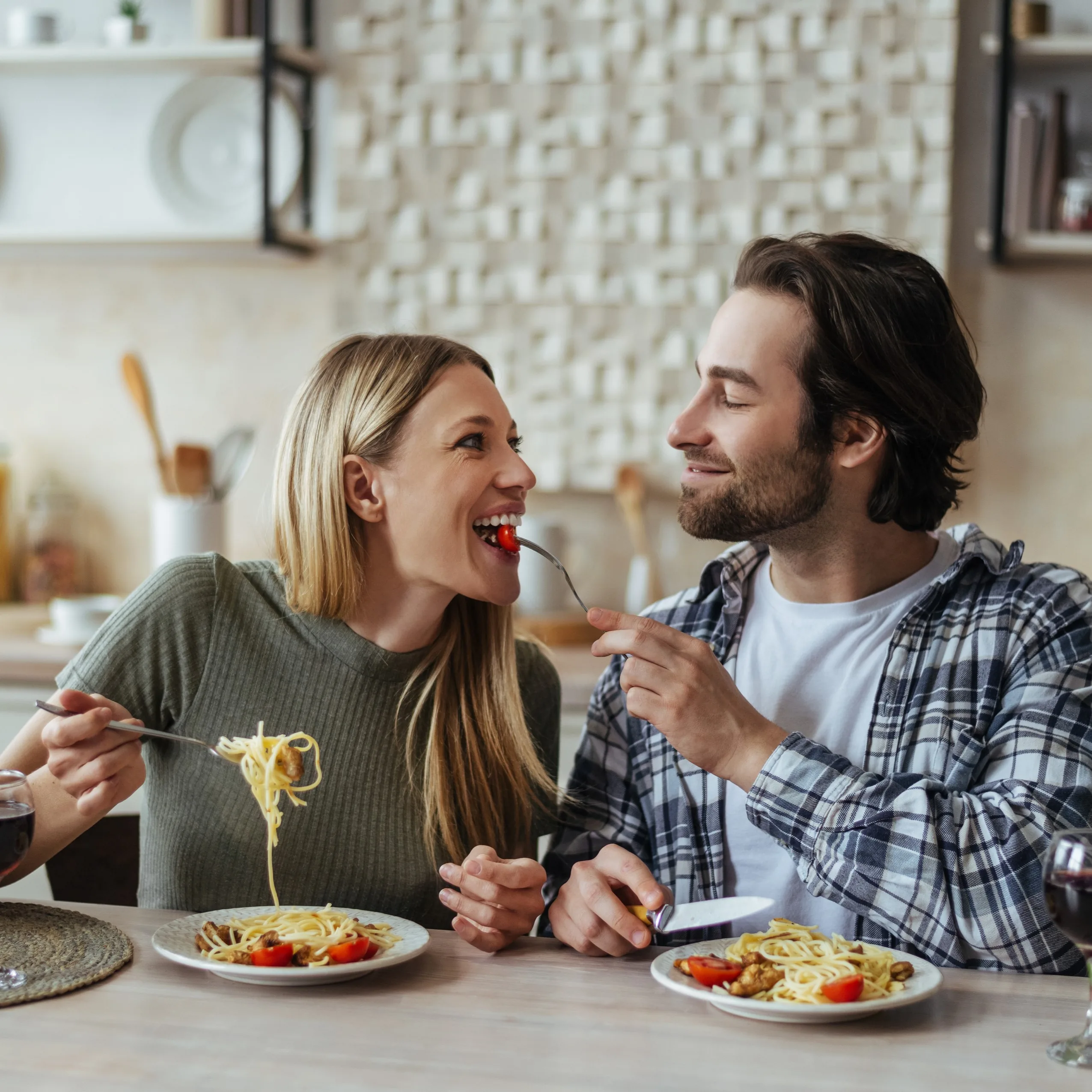 Ein glückliches Pärchen das zusammen Spagetti isst.
